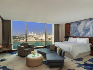 a hotel room with a bed and a large window at Fairmont Bab Al Bahr in Abu Dhabi
