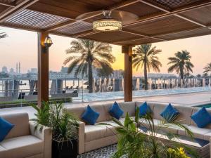 a living room with a couch and palm trees at Fairmont Bab Al Bahr in Abu Dhabi