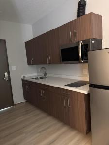 a kitchen with a sink and a refrigerator at Hotel de Luxe Extended Stay in Sulphur