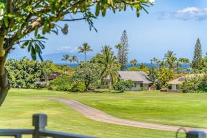 a golf course with palm trees and a house at Grand Champions 163 · GC 163 2BD Wailea Condo w AC Pool Close to in Wailea