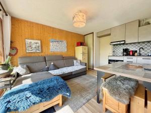 un soggiorno con un divano e un tavolo di Appartement cosy avec terrasse et parking proche centre - FR-1-505-235 a Notre-Dame-de-Bellecombe