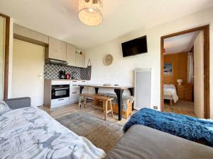 una camera da letto con un letto e una cucina con un tavolo di Appartement cosy avec terrasse et parking proche centre - FR-1-505-235 a Notre-Dame-de-Bellecombe Altre 14 foto