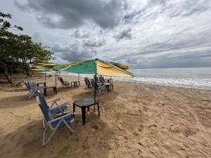 Una playa con sillas y sombrillas y el océano. en Pousada Marina bonita Rasa, en Búzios