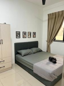 a bedroom with a bed with a dog laying on it at FA Homestay KLIA 3rd Unit in Nilai