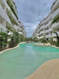 a swimming pool in front of a apartment building at Tulum Getaway with Jacuzzi & Pools in Tulum