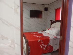 a bedroom with a bed with a red and white blanket at Villa colombia in Miches +6 photos