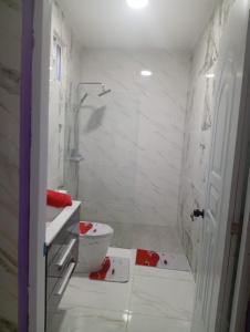 a white bathroom with a toilet and a sink at Villa colombia in Miches