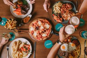 a group of people sitting around a table with plates of food at Claremont Hotel in Claremont