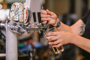 a person pouring a glass of beer at a bar at Claremont Hotel in Claremont