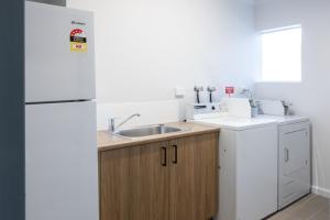 a kitchen with a sink and a refrigerator at Claremont Hotel in Claremont +2 photos