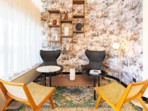 アヌシーにあるLe Splendid Hotel Lac D'Annecy - Handwritten Collectionの椅子2脚とテーブル1台が備わる壁の客室です。