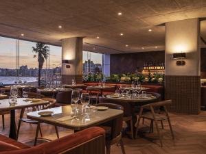 - un restaurant avec des tables et des chaises offrant une vue dans l'établissement Costanero Hotel Montevideo - MGallery Collection, à Montevideo