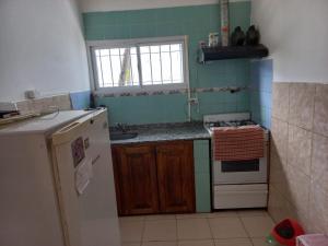a small kitchen with a stove and a refrigerator at La Casa de Doña Adela in Eugenio Bustos