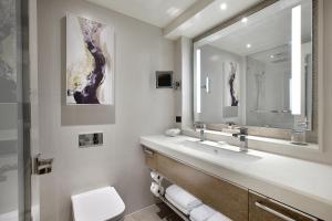 a bathroom with a sink, toilet and mirror at The Star Grand at The Star Gold Coast in Gold Coast