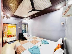 a bedroom with two beds and a ceiling fan at Reddy home stay in Hampi