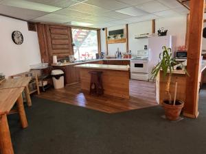 a large kitchen with wooden floors and a white refrigerator at Anglemont Inn Rent all 16 Rooms for Weddings, Events North Shuswap BC in Anglemont +16 photos