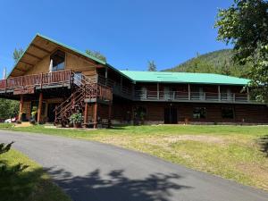 a large log house with a green roof at Anglemont Inn Rent all 16 Rooms for Weddings, Events North Shuswap BC in Anglemont
