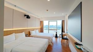 广州琶心酒店公寓 Pace Hotel Apartment- Pazhou Station -Line8 and Line11 - few minutes' walk to Canton Exhibition Center的有两张床和一扇大窗户的酒店房间