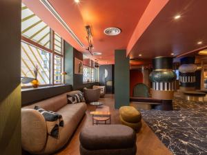 a living room with a couch and chairs and a table at Nest Hotel Paris la Défense - MGallery Collection in Puteaux