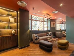 a living room with a couch and a table at Nest Hotel Paris la Défense - MGallery Collection in Puteaux