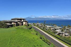 a road leading to a resort on a hill next to the ocean at Kapalua Ridge Villas 1011 · KRV 1011 Oceanview Condo + Golf + Lu in Kahana