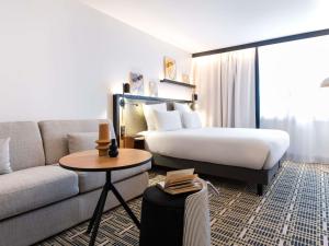 a hotel room with a bed and a couch at Mercure Paris Bercy Bibliothèque in Paris