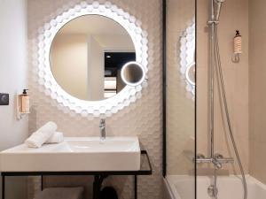 a bathroom with a sink and a mirror and a shower at Mercure Paris Bercy Bibliothèque in Paris +116 photos