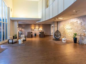 a lobby with a large room with a stone wall at Mercure Salzburg City in Salzburg
