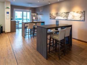 una sala da pranzo con tavolo e sgabelli da bar di Mercure Salzburg City a Salisburgo Altre 54 foto