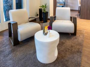 two white chairs and a table in a room at Mercure Salzburg City in Salzburg +53 photos
