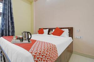 a hotel room with a bed with red pillows at Hotel O Kalot in Jaipur