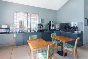 a kitchen with blue cabinets and a table and chairs at Super 8 by Wyndham Wisconsin Dells in Wisconsin Dells