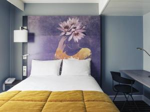 a bedroom with a bed and a painting on the wall at Mercure Nancy Centre Place Stanislas in Nancy