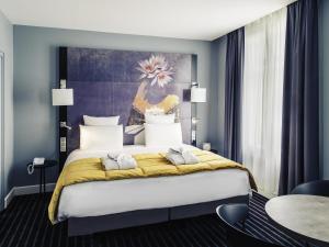 a bedroom with a large bed with a yellow blanket at Mercure Nancy Centre Place Stanislas in Nancy +135 photos