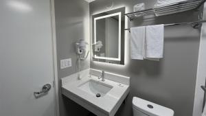 a white bathroom with a sink and a mirror at Motel 6 Rockford, IL – RFD Airport in Rockford +17 photos