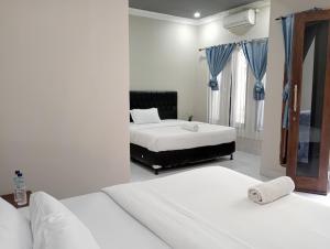 a bedroom with two beds and a tub in it at Ayu Homestay in Kuta Lombok