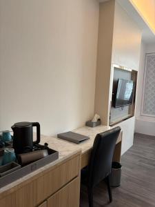 a kitchen with a desk with a sink and a mirror at lee hotel lat phrao in Bangkok