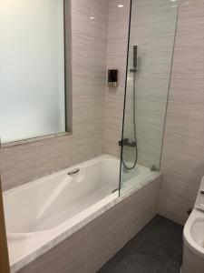 a bathroom with a shower and a tub and a toilet at lee hotel lat phrao in Bangkok