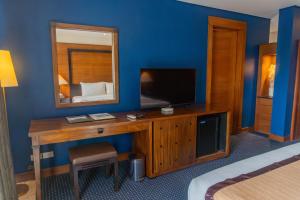 a room with a desk with a television and a mirror at Boracay Sands Hotel in Boracay