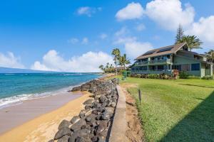 a house on the beach next to the ocean at Kahana Outrigger 3A2 · KHO 3A2 Updated OceanFront 3BD wPool AC O in Kahana