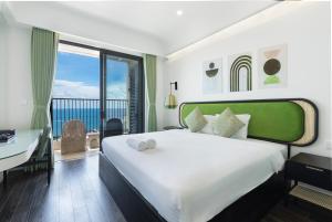 a bedroom with a bed and a desk and a window at Atermis Regency Hillside Phu Quoc - Sea & Fireworks view- Gym & Pool Access in Phu Quoc