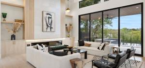a living room with white furniture and large windows at Barton Springs Luxe Heated Pool Spa Sleeps 16 in Austin