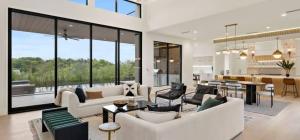 a living room with white couches and a dining room at Barton Springs Luxe Heated Pool Spa Sleeps 16 in Austin