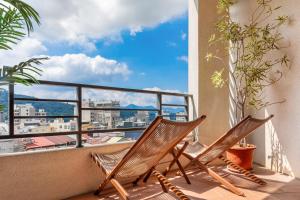 2 Stühle auf einem Balkon mit Stadtblick in der Unterkunft ItaThao Smart Stay with Elevator in Yuchi