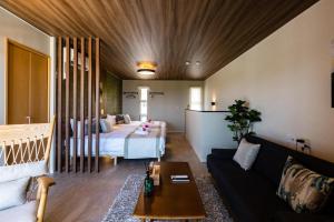 a living room with a bed and a couch at Alpha Terrace Motobu Hills in Motobu