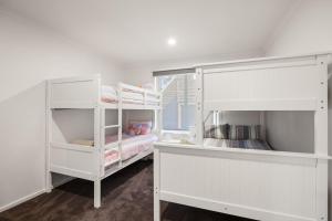 a white room with two bunk beds and a window at Irving House in Cowes