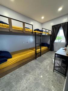 セキンチャンにあるTY Youth Hostelの二段ベッド2台、デスクが備わる客室です。