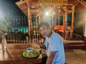 PanaotiBalthali Heritage Inn的吃一盘食物的人