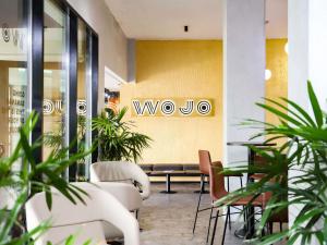 a lobby with awwoice sign on a wall with plants at Pullman Abidjan in Abidjan