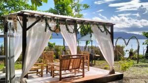 cenador con sillas y sombrilla en Rumah Arunika 27, 